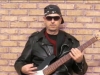 Frank on bass guitar - brick background portrait (from the Reaction 7 video 